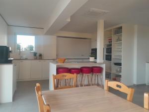 ZottegemVakantiehuis 't Alkeveld的厨房配有木桌和红色凳子