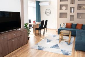 een woonkamer met een blauwe bank en een tafel bij Gondola Apartments Lux in Bansko