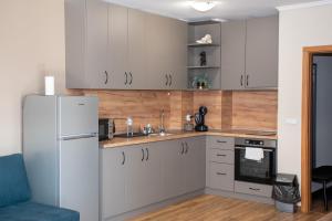 een keuken met witte kasten en een koelkast bij Gondola Apartments Lux in Bansko
