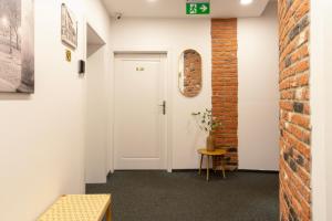 a hallway with a white door and a brick wall at Kazimierz Residence Apartments Parking - by Staymoovers in Krakow