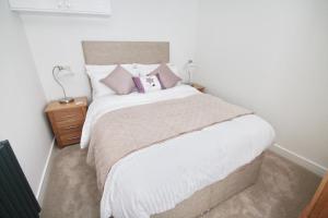 a bedroom with a large bed with two pillows on it at Courtside Apartment Southsea in Portsmouth