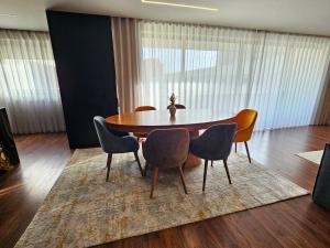 a dining room with a table and chairs on a rug at Luxury Rooftop Apartment by LuxiStay – Private Jacuzzi & Sunset Views | Matosinhos in Matosinhos