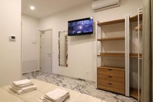 a bedroom with a tv on the wall and a closet at b&b la cattedrale in Avezzano