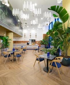 a restaurant with tables and chairs and potted plants at INFINITY Budapest Hotel - Adults Only in Budapest