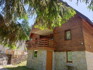 Una casa de madera con un balcón en la parte superior. en Vikend kuća Libertas, en Šišava