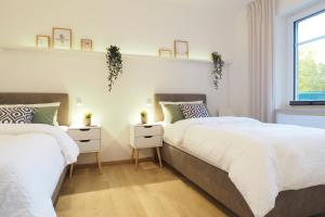 two twin beds in a bedroom with white walls at "Skandi-Lounge" - Naturnahe Ferienwohnung mit Kaffeebar, schnellem Internet und Wallbox in Beverstedt