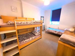 ein Zimmer mit zwei Etagenbetten und einem Fenster in der Unterkunft 1 Belmont Court in Woolacombe