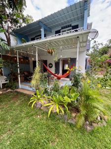 ein Haus mit einer Veranda mit Pflanzen im Hof in der Unterkunft Maison avec jardin à Grand Gaube a 1 min de la plage in Grand-Gaube