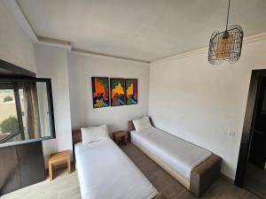 a room with two beds and a window at Atlantic View Duplex Tawenza Bay in Taghazout +43 photos