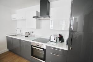 a kitchen with a sink and a refrigerator at Courtside Apartment Southsea in Portsmouth