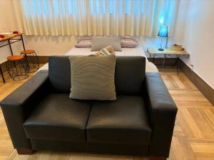 a living room with a couch and a bed at Loft 1 Elegante e Aconchegante Airport GRU in Guarulhos