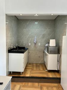 a kitchen with a counter and a sink in a room at Loft 1 Elegante e Aconchegante Airport GRU in Guarulhos