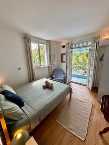 ein Schlafzimmer mit einem großen Bett und einem großen Fenster in der Unterkunft Maison avec jardin à Grand Gaube a 1 min de la plage in Grand-Gaube