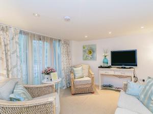 d'un salon avec des chaises en osier et une télévision à écran plat. dans l'établissement The Gatehouse-Uk11836, à Dronfield 10 autres photos