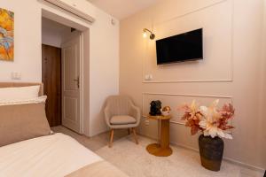 a bedroom with a bed and a chair and a tv at Kazimierz Residence Apartments Parking - by Staymoovers in Krakow +69 photos