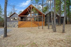 une maison en rondins avec un toit en gambrel dans l'établissement Whispering Winds, Luxury Cabins, Sleeps 22, à Broken Bow