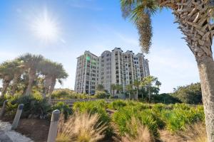 a tall building with palm trees in front of it at Florencia 708 by Liquid Life in Pensacola