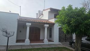une maison blanche avec un portail et une voiture dans l'établissement Pausa mendocina centro, à San Rafael