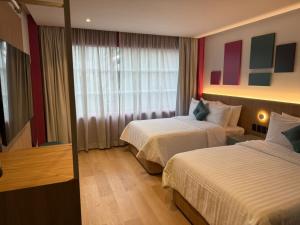 een hotelkamer met twee bedden en een raam bij Hotel More By Kavia in Mexico-Stad