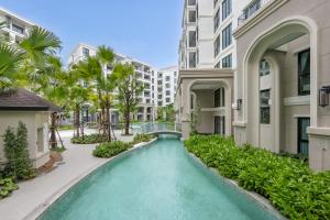 une piscine dans la cour d'un immeuble dans l'établissement Oliva 1BR Suite — The Title Legendary BangTao, à Bang Tao Beach