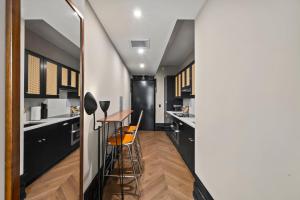 eine Küche mit schwarzen Schränken sowie einem Tisch und Stühlen in der Unterkunft Freeman 901 by Rove Studio with Shared Amenities in New York