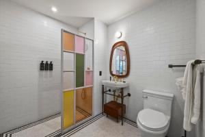 ein Badezimmer mit Toilette, Waschbecken und Spiegel in der Unterkunft Freeman 901 by Rove Studio with Shared Amenities in New York + 19 Fotos