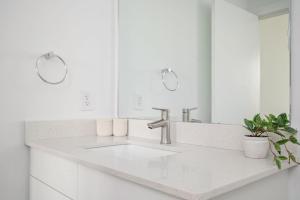 ein weißes Badezimmer mit Waschbecken und Spiegel in der Unterkunft Luxury 5Beds 3Baths 2Balcony Penthouse 542Blvd in Atlanta