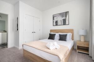 ein Schlafzimmer mit einem Bett mit weißen Laken und Kissen in der Unterkunft Luxury 5Beds 3Baths 2Balcony Penthouse 542Blvd in Atlanta + 27 Fotos