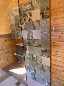 una parete in vetro in una stanza con pavimento in legno di Barrel Orange a Saint-André