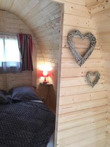 una camera da letto in una baita di tronchi con una parete a forma di cuore di Barrel Orange a Saint-André