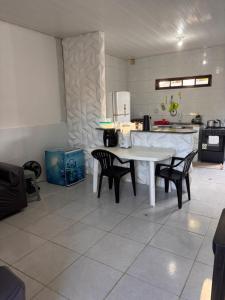 a kitchen with a white table and chairs in it at Casa praia do frances in Marechal Deodoro +5 photos