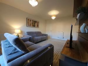 a living room with a couch and a tv at STYLISH & SPACIOUS 4 BEDROOM HOUSE - FREE DRIVEWAY PARKiNG in Shrewsbury