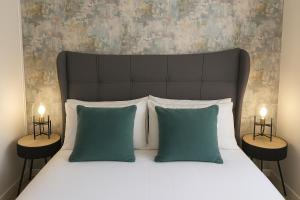 a bedroom with a bed with green pillows and two lamps at STYLISH & SPACIOUS 4 BEDROOM HOUSE - FREE DRIVEWAY PARKiNG in Shrewsbury