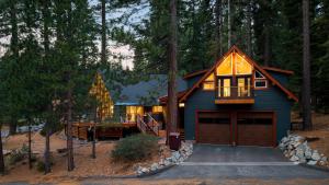 una casa blu con un garage nel bosco di Retreat with Lake Access Deck Modern Interior Agate Peak by Avantstay a Tahoe Marina Estates
