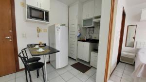 a small kitchen with a table and a refrigerator at Aconchegante proxima ao parque e ao setor hospitalar in Brasilia