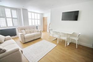 a living room with a couch and a table at Courtside Apartment Southsea in Portsmouth
