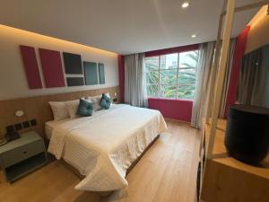 een slaapkamer met een groot bed en een groot raam bij Hotel More By Kavia in Mexico-Stad +8 foto's