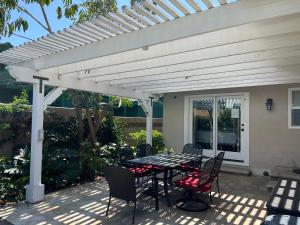 a patio with a table and chairs under a white pergola at Destination #23 in Anaheim