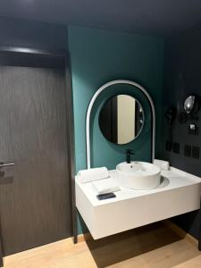 een badkamer met een witte wastafel en een spiegel bij Hotel More By Kavia in Mexico-Stad