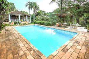 a swimming pool in a yard with a gazebo at Quinta do Vale: Casa flutuante, 90km de SP - Lago, cascata, piscina, tranquilidade in Itatiba