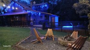 eine Gruppe von Stühlen, die nachts in einem Hof sitzen in der Unterkunft Pousada Caminho do Lago in Rio Rufino