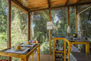 eine abgeschirmte Veranda mit einem Tisch und einem Waschbecken in der Unterkunft Casa de Vidro 2, há 90km de São Paulo, com Lago, Piscina, Caiaque, Stand UP, Cascata e Escorrega no Lago - Quinta do Vale Itatiba in Itatiba + 23 Fotos