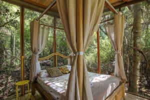 ein Schlafzimmer in einem Baumhaus im Wald in der Unterkunft Casa de Vidro 2, há 90km de São Paulo, com Lago, Piscina, Caiaque, Stand UP, Cascata e Escorrega no Lago - Quinta do Vale Itatiba in Itatiba
