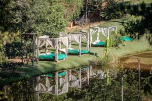 Ein Tisch und Stühle spiegeln sich in einem Gewässer in der Unterkunft Casa de Vidro 2, há 90km de São Paulo, com Lago, Piscina, Caiaque, Stand UP, Cascata e Escorrega no Lago - Quinta do Vale Itatiba in Itatiba