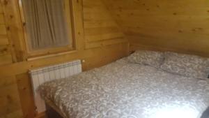 a bedroom with a bed in a log cabin at Holiday Home Floris in Kopaonik