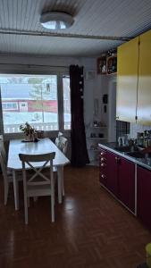 een keuken met een witte tafel en een tafel en stoelen bij Do you like peace and silence in Tervola