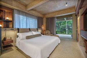 a bedroom with a large white bed and a large window at 23 Living in Medellín