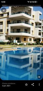 un grande edificio con una piscina di fronte di Résidence Ebla a Minaret de Mansuria