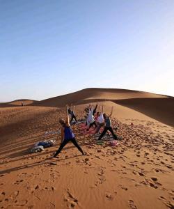 Eine Gruppe von Menschen tanzt in der Wüste in der Unterkunft Camp azawan hananich 
