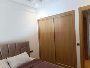 una camera da letto con un grande armadio di legno accanto al letto di Résidence Ebla a Minaret de Mansuria